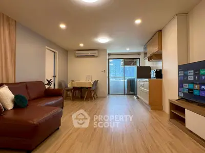 Spacious living room with modern kitchen and balcony view, perfect for urban living.