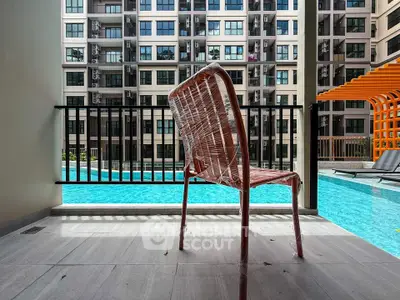 Modern apartment balcony overlooking a pool with a wrapped chair, perfect for relaxation.