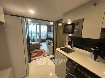 Modern open-layout kitchen with sleek appliances and cozy living area with city view.