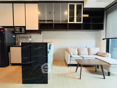 Modern open-layout living room with sleek kitchen and cozy sofa