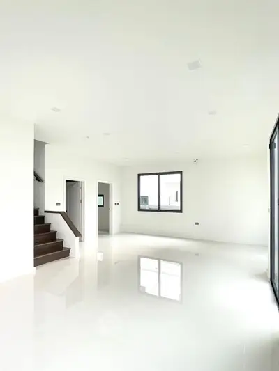 Spacious modern living room with glossy white tiles and large windows