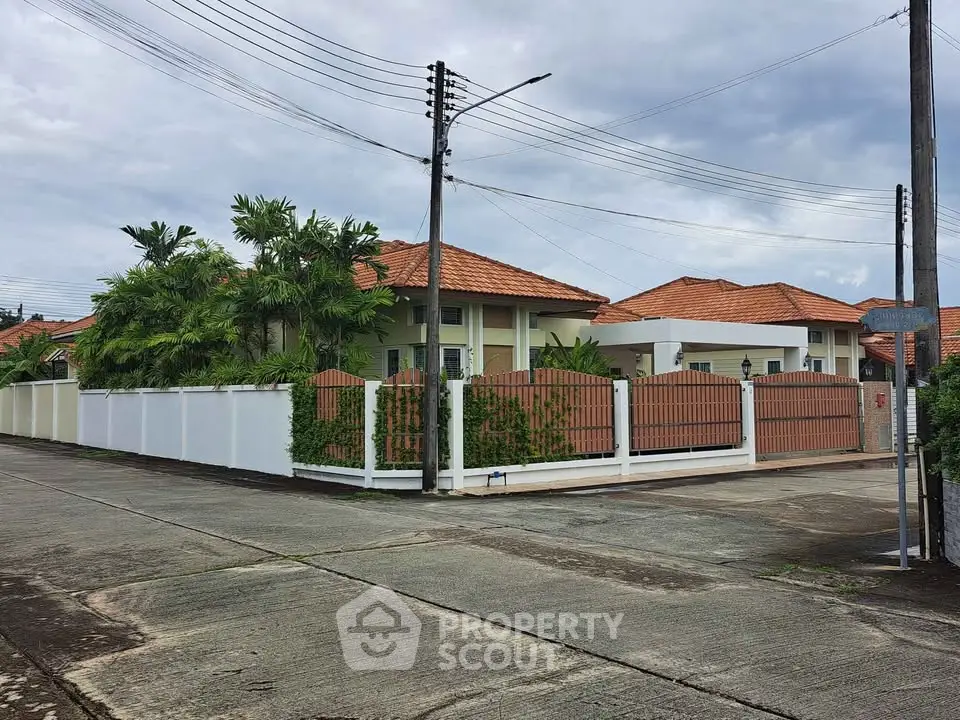 Charming suburban home with red-tiled roof and lush greenery, perfect for family living.