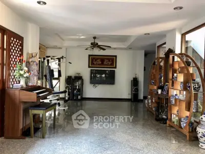 Spacious living area with polished floors, ceiling fan, and ample natural light, perfect for family gatherings and entertainment.