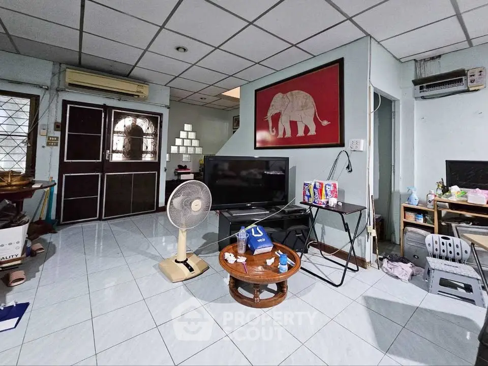 Spacious living room with modern decor and large TV, perfect for relaxation and entertainment.