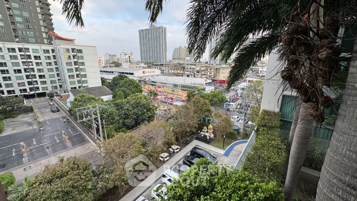 Stunning urban view from high-rise balcony overlooking cityscape and greenery.