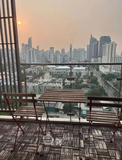 Stunning city view from a modern balcony with stylish outdoor seating.