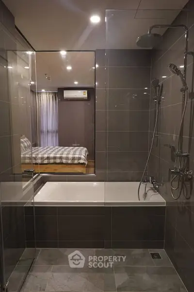 Modern bathroom with glass shower and bathtub, view into stylish bedroom with air conditioning.