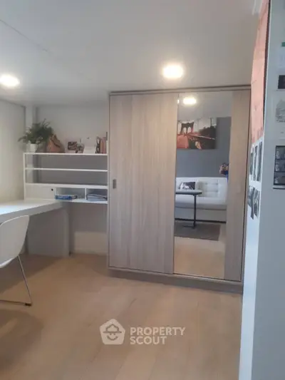 Modern study room with sleek desk and mirrored wardrobe in stylish apartment.