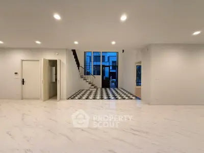 Spacious modern interior with elegant staircase and marble flooring, perfect for luxurious living.