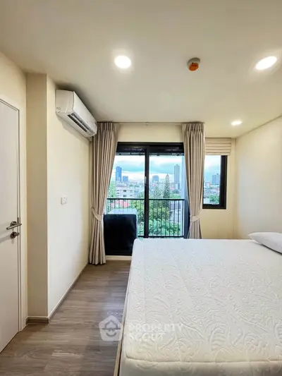 Bright bedroom with city view, featuring a large window, air conditioning, and modern decor.