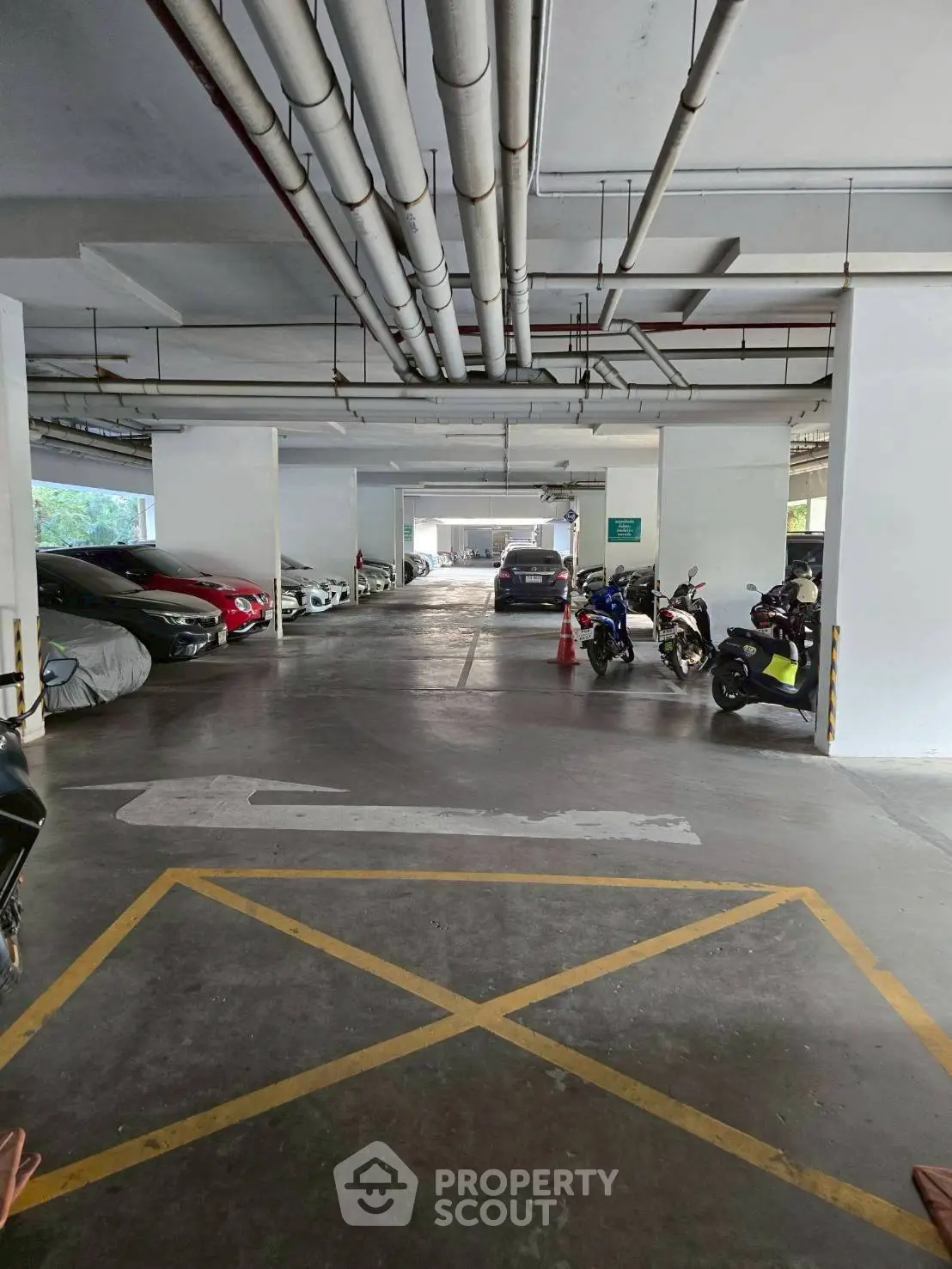 Spacious indoor parking area with multiple vehicles and clear markings.