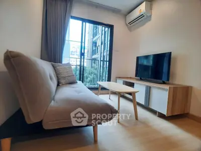 Modern living room with stylish sofa, TV, and large window offering city views.