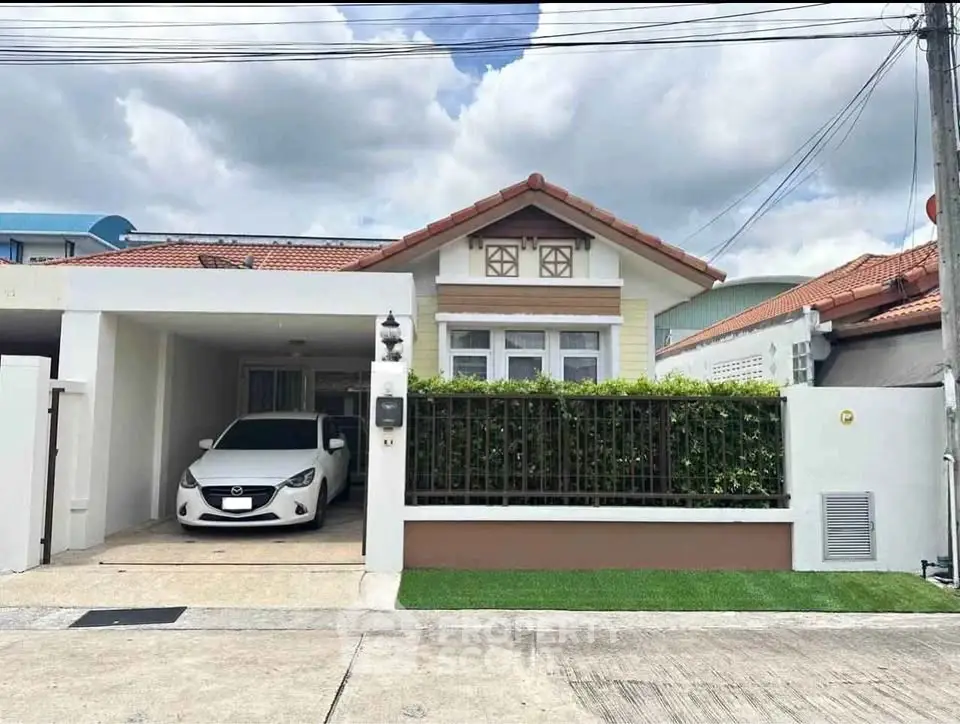 Charming single-story house with carport and lush greenery in a serene neighborhood.