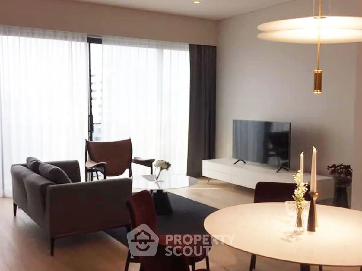 Modern living room with stylish furniture and large windows offering natural light.