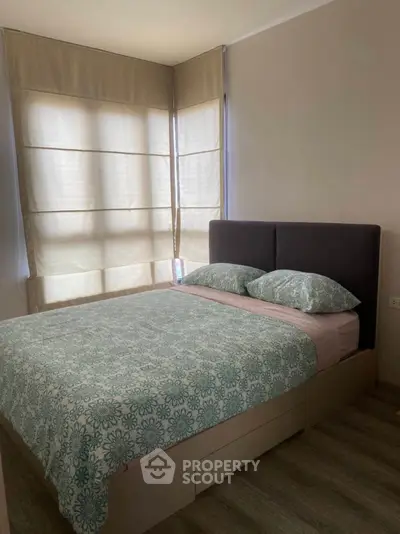 Cozy bedroom with modern decor and large windows for natural light.