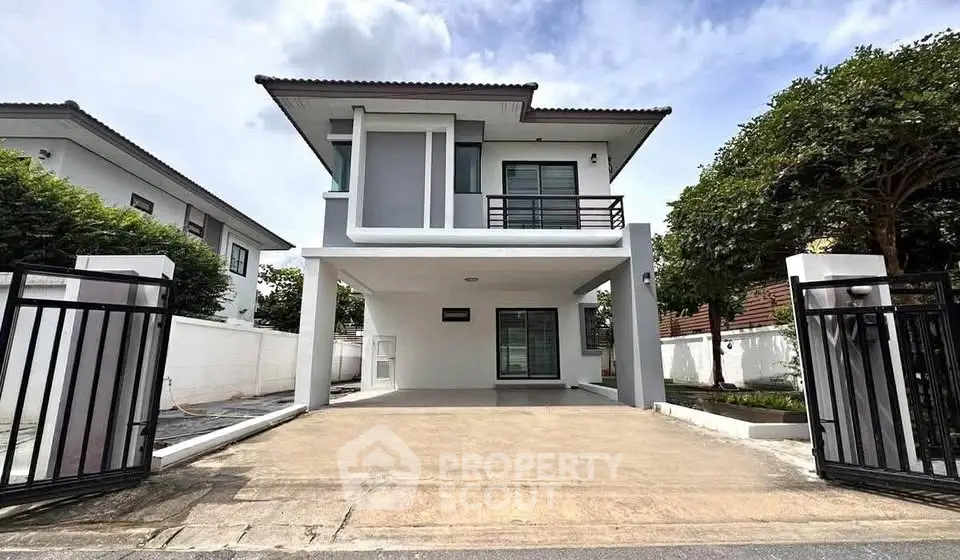 Modern two-story house with spacious driveway and sleek design in a serene neighborhood.