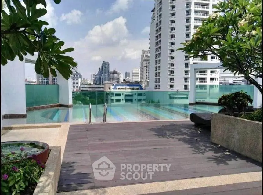 Luxurious rooftop pool with stunning city skyline views and lush greenery.