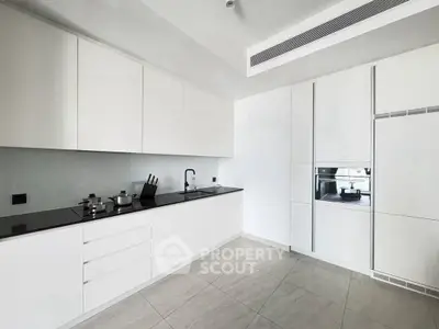 Modern kitchen with sleek white cabinetry and built-in appliances in a minimalist design.