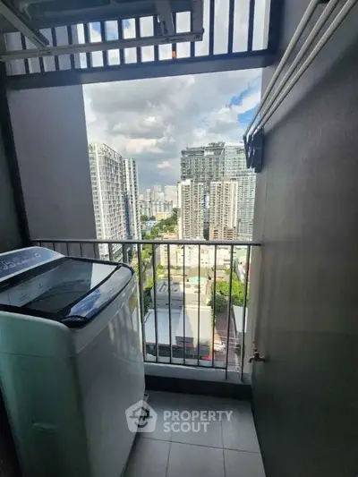 High-rise apartment balcony with washing machine and city skyline view.