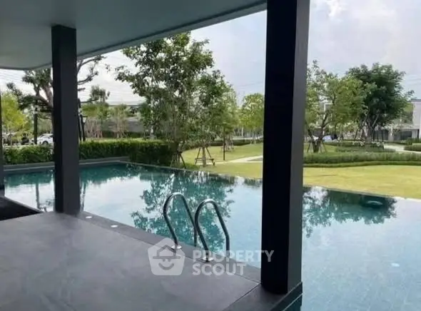 Luxurious outdoor pool with serene garden view in modern residential complex.