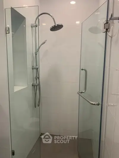 Modern glass-enclosed shower with sleek fixtures in a contemporary bathroom setting.