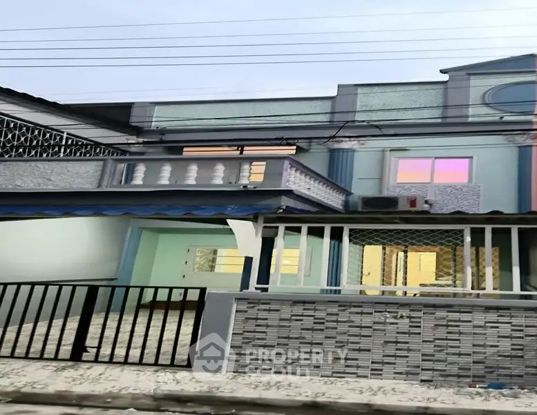 Charming two-story house with unique architectural details and spacious balcony.