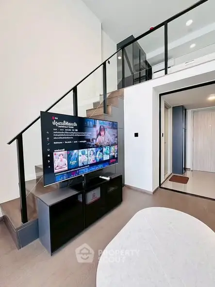Modern living room with sleek staircase and large TV in stylish apartment