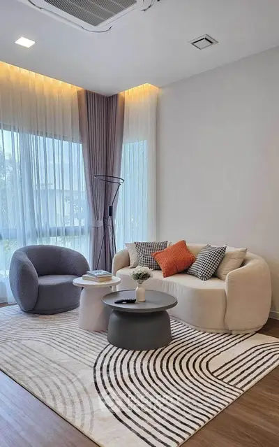 Modern living room with stylish furniture and large windows offering natural light.