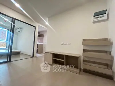 Modern apartment interior with open layout and sleek design, featuring a cozy living area and a glimpse of the kitchen.