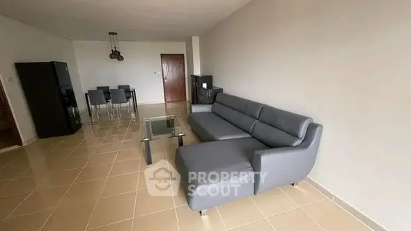 Spacious living room with modern gray sofa and dining area