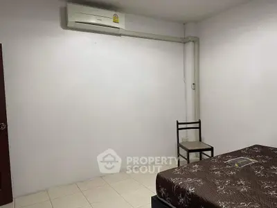 Minimalist bedroom with air conditioning and simple furnishings