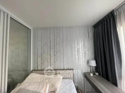 Cozy bedroom with modern decor and natural light, featuring elegant wallpaper and stylish furnishings.