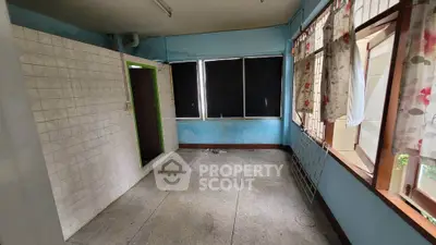Spacious room with large windows and tiled section, potential for renovation.