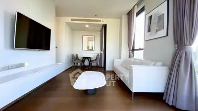 Modern living room with sleek furniture and large windows offering natural light.