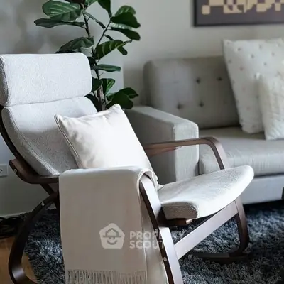 Stylish living room with modern armchair, cozy sofa, and lush plant decor.
