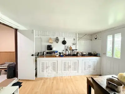 Charming kitchen with white cabinetry and wooden countertops, featuring a cozy open layout and natural light.