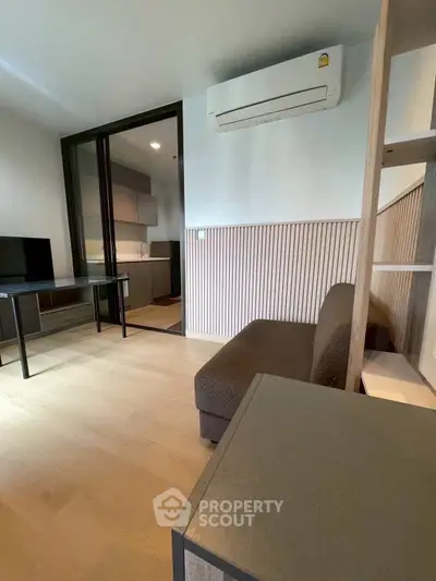 Modern living room with air conditioning and open kitchen layout in a stylish apartment.