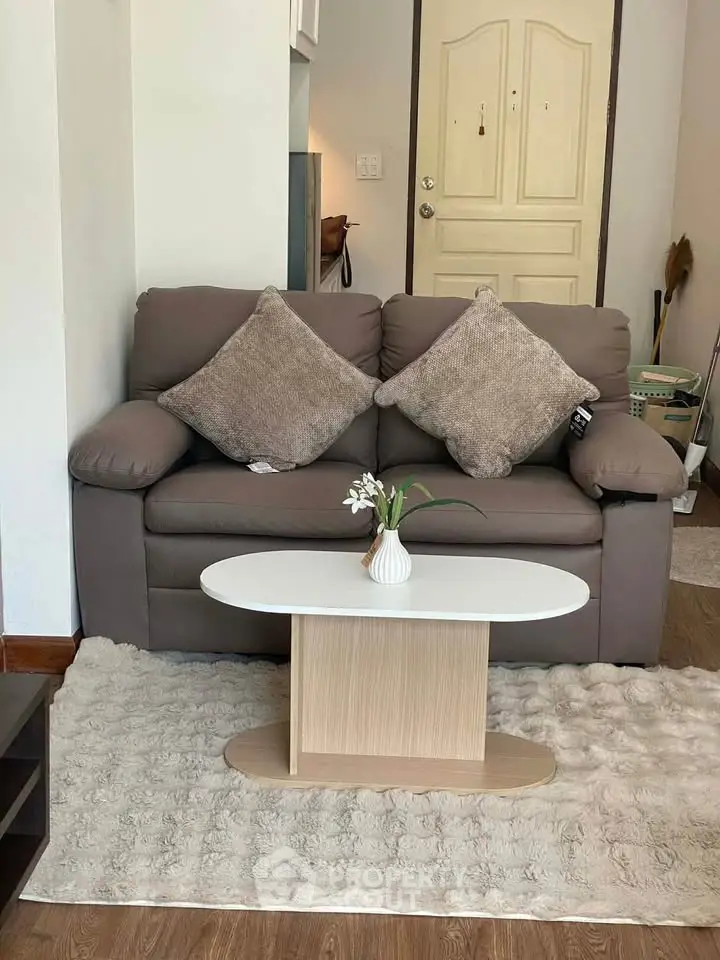 Cozy living room with plush sofa and modern coffee table, perfect for relaxation.