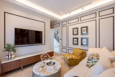 Stylish living room with modern decor, featuring a wall-mounted TV and cozy seating area.