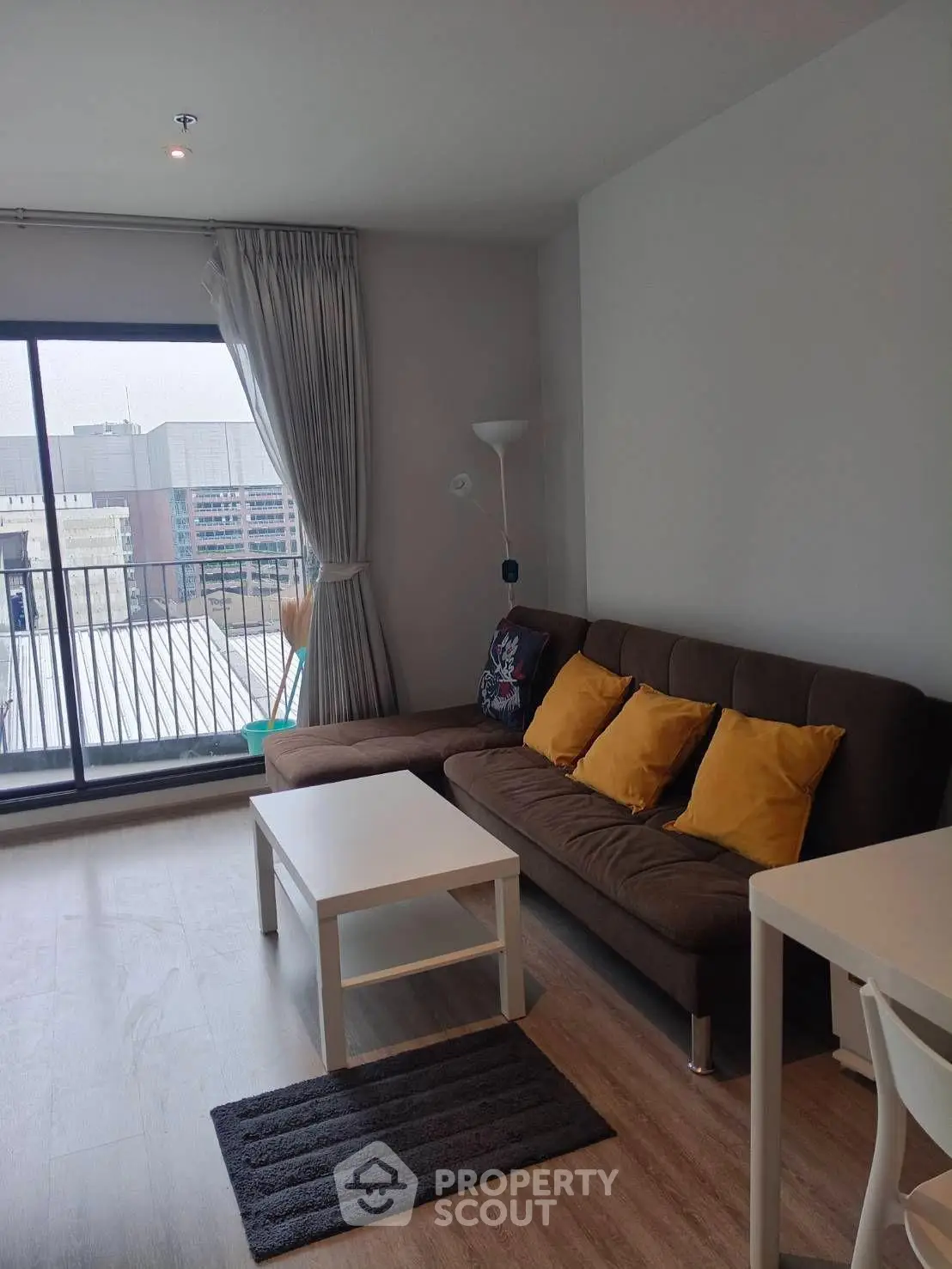 Modern living room with city view, featuring a cozy sofa and stylish decor.