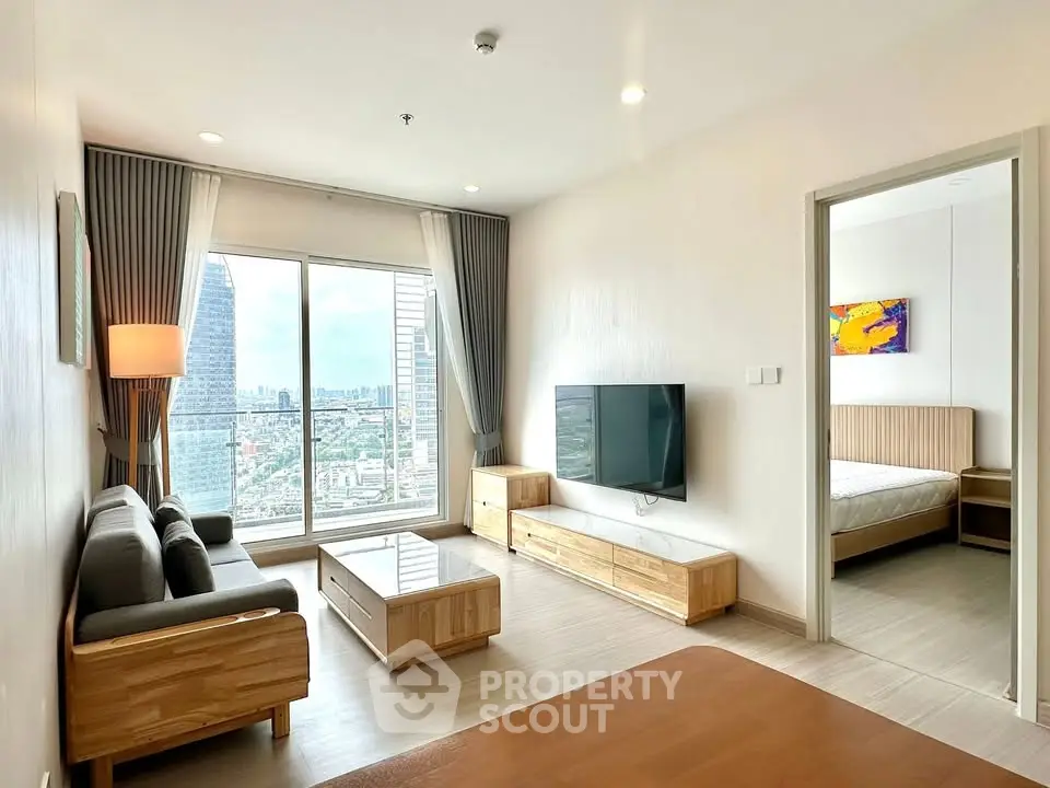 Modern living room with city view, featuring sleek furniture and large windows for natural light.