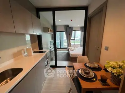 Modern studio apartment with compact kitchen and cozy bedroom, featuring stylish decor and city view.