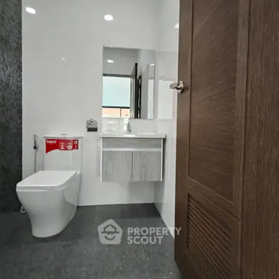 Modern bathroom with sleek design and contemporary fixtures, featuring a stylish vanity and elegant flooring.