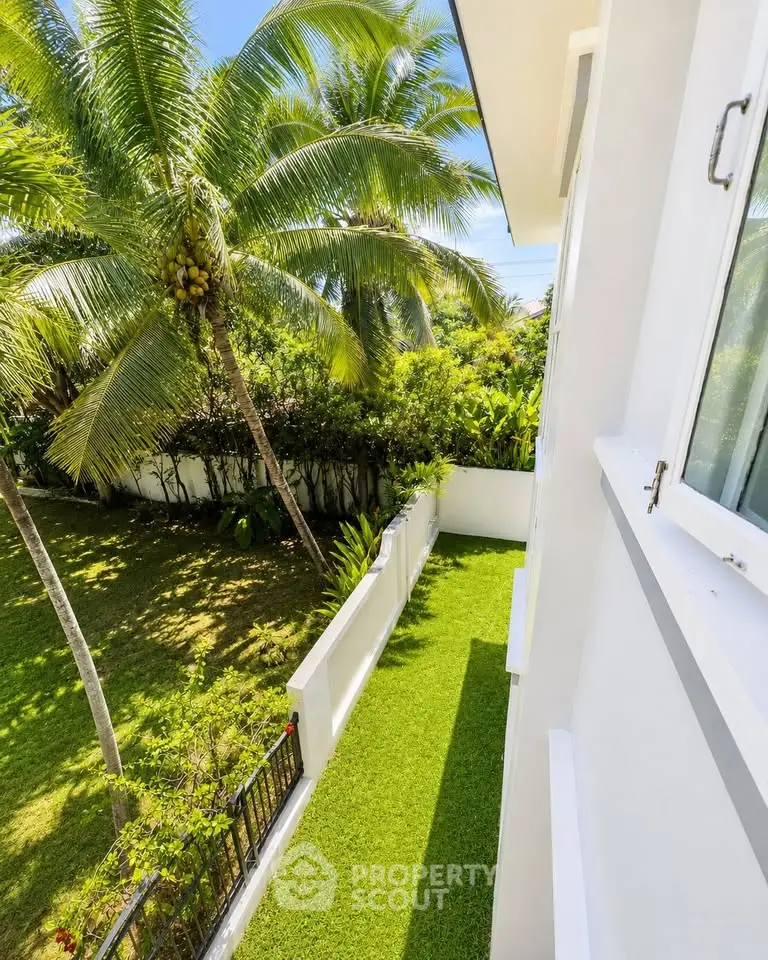 Stunning tropical garden view from modern building balcony, showcasing lush greenery and serene outdoor space.