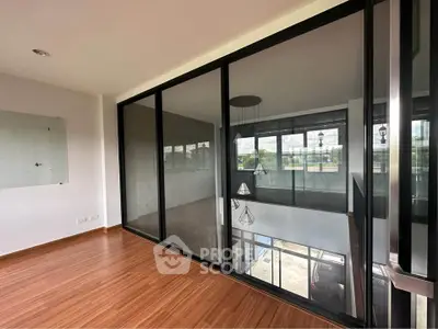 Spacious modern room with large glass windows and wooden flooring