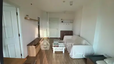 Cozy living room with wooden flooring and modern furniture in a bright apartment.
