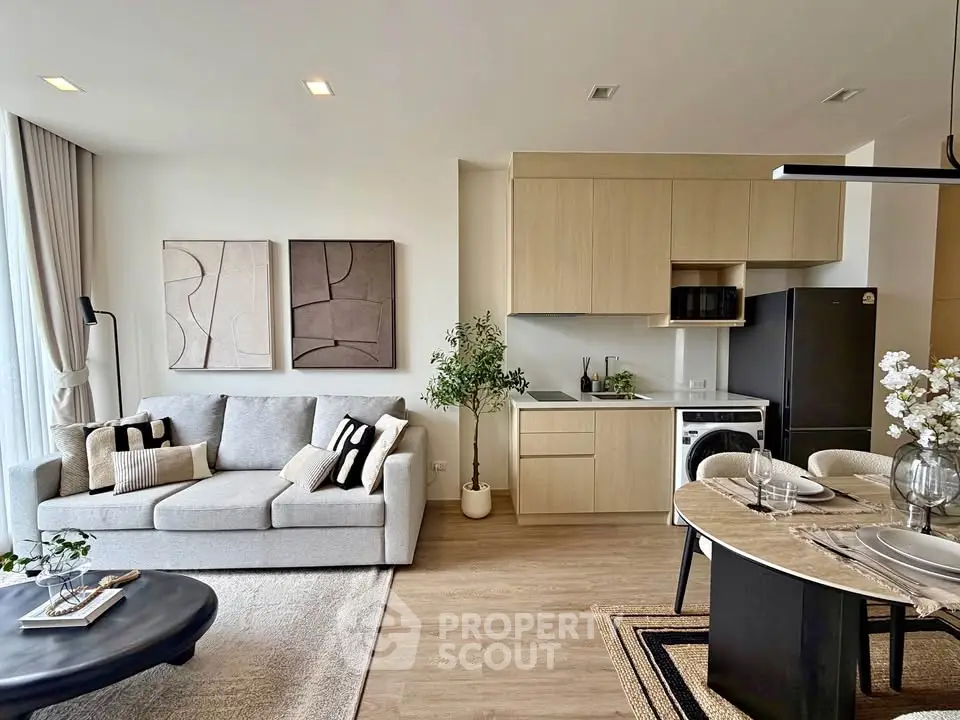 Modern open-plan living room and kitchen with stylish decor and natural light.