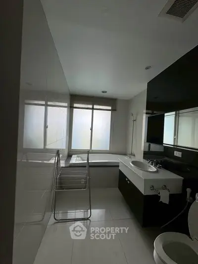 Modern bathroom with sleek design, featuring a bathtub and large windows for natural light.