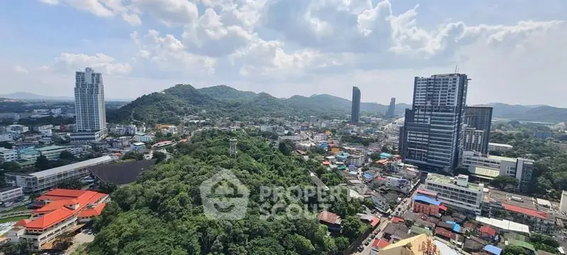 Stunning panoramic cityscape view with lush greenery and modern high-rise buildings under a clear blue sky.