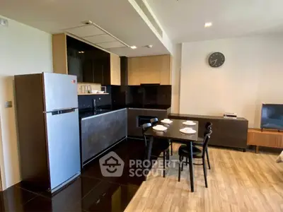 Modern kitchen with dining area, featuring sleek appliances and stylish decor.